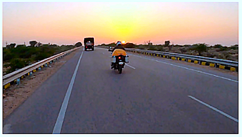 Tarmac road with motorcycle and sunset